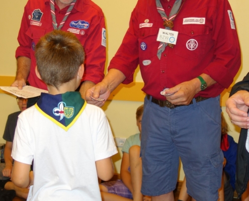Abzeichenverleihung Das Bild zeigt Stefan und Walter aus dem BZW-Team beim Verleihen eines Abzeichens an ein Pfadi-Kind